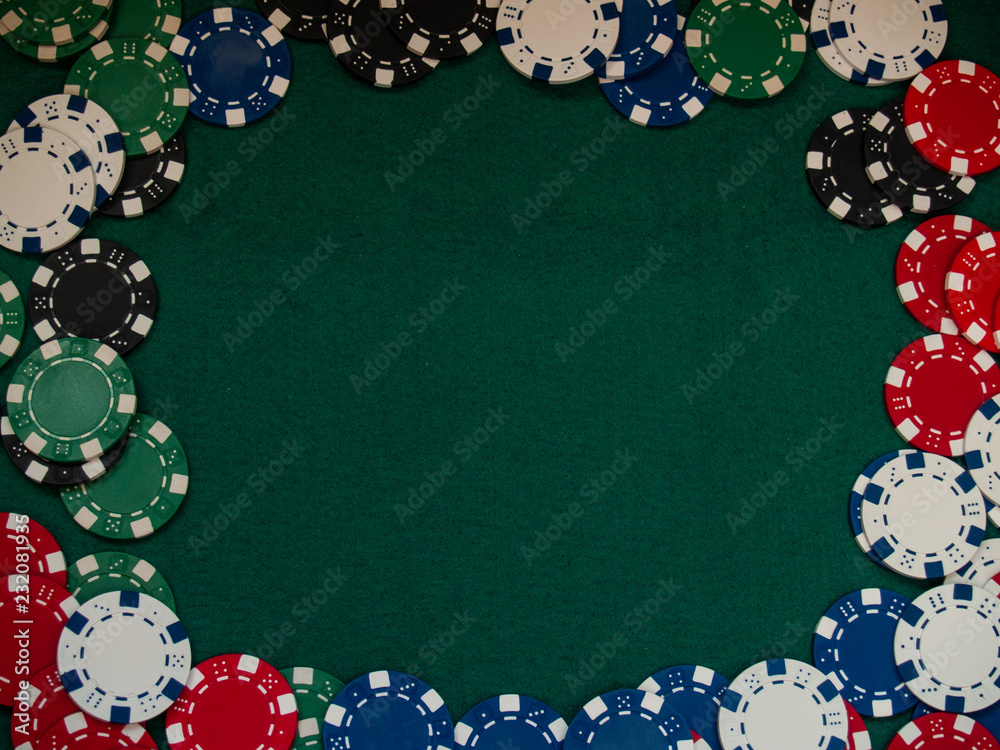 Poker chips of various colors on a green mat Poker chips of various colors on a green mat