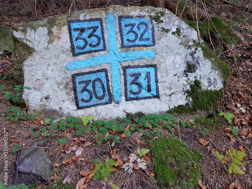 blaue Nummern auf Stein als Wanderweg Markierungen photo