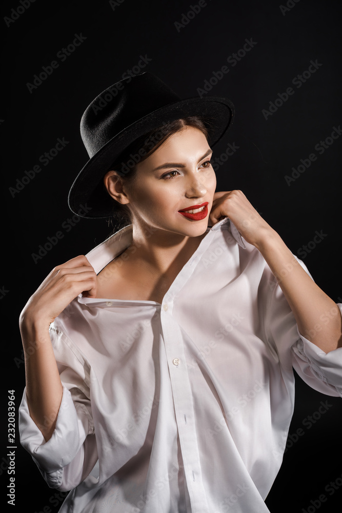 stylish young model with red lips in white shirt and black hat posing isolated on black stylish young model with red lips in white shirt and black hat posing isolated on black