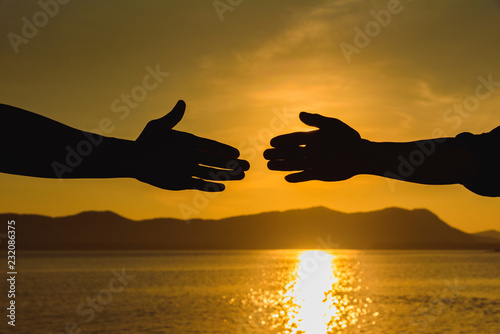 Silhouette of helping hand concept and international day of peace, Expression of Business Collaboration, Help hand, Teamwork concept, Business handshake ideas.