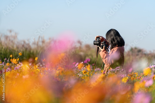 Women are taking photos in the garden.