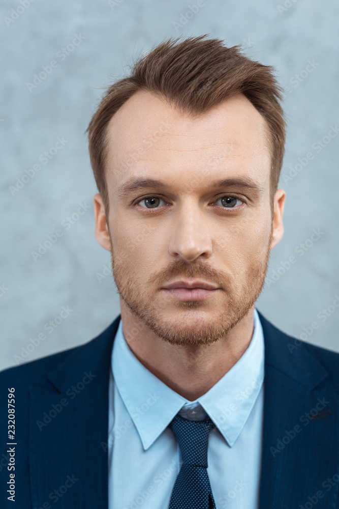 close up portrait of handsome young businessman looking at camera in office close up portrait of handsome young businessman looking at camera in office