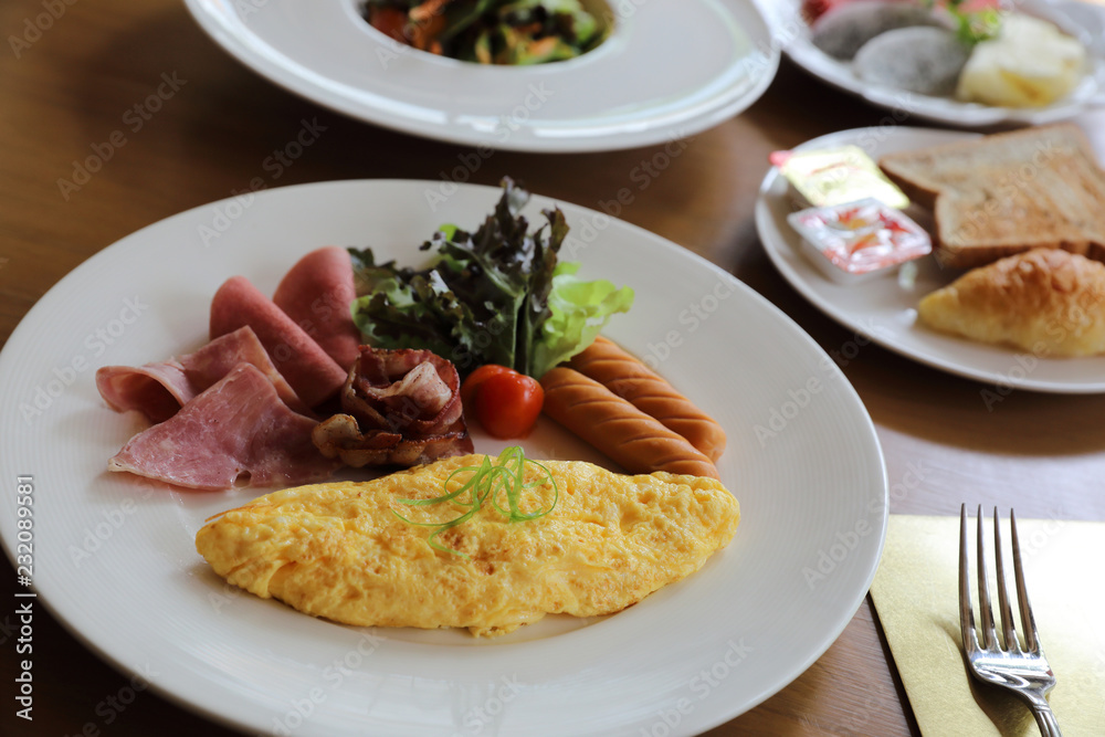 Breakfast set Omelette with sausage bacon and salad on wood background Breakfast set Omelette with sausage bacon and salad on wood background