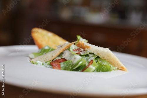 fresh salad with bacon and bread on wooden background