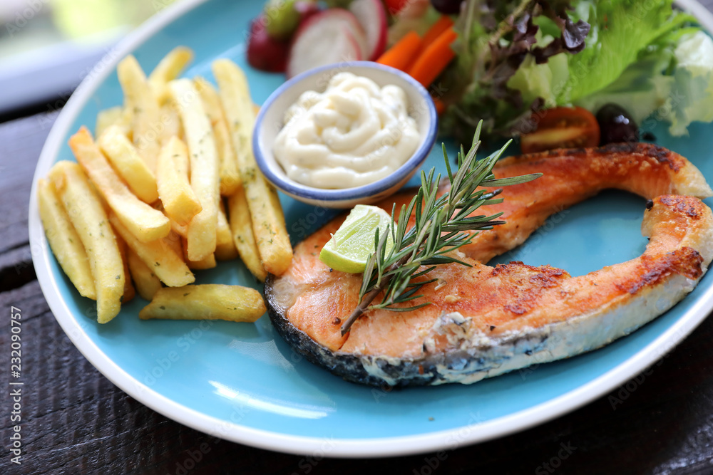 Roasted salmon steak , baked salmon with salad fresh vegetable pm wooden table Roasted salmon steak , baked salmon with salad fresh vegetable pm wooden table
