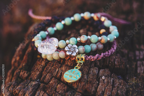 Three bracelets with gemstone beads on wooden background