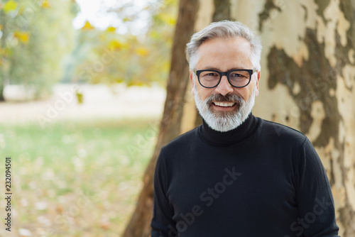 Handsome bearded man smiling happily at camera