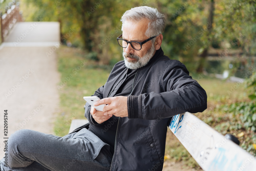 Attractive mature man relaxing on a park bench Attractive mature man relaxing on a park bench
