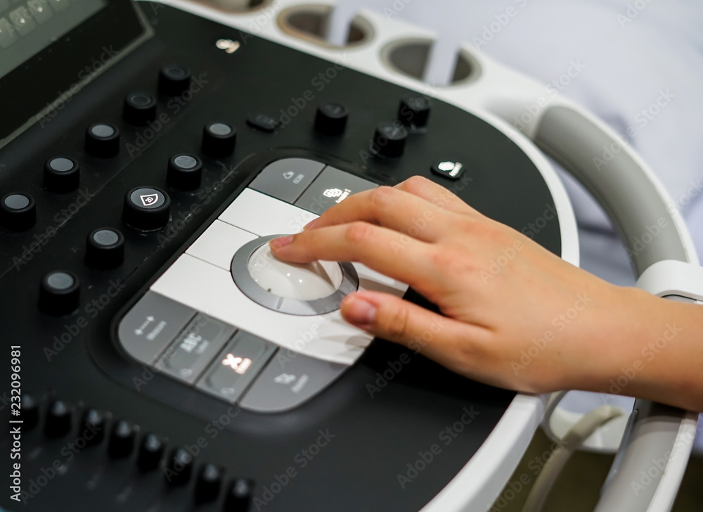 Doctor hand pressing on control panel button of ultrasound machine, Medical equipment concept Doctor hand pressing on control panel button of ultrasound machine, Medical equipment concept