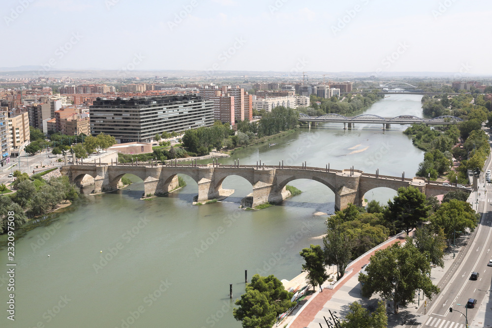 A landscape of Zaragoza city, with Ebro river shores, the Stone and Iron bridges, a seen from the Pilar Catedral bell tower, Spain