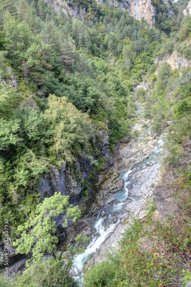 The waterfalls and the rapids in the Rio Bellos canyon on the forest covered rocky mountains in the Cañon de Añisclo valley, in Aragon region, Spain The waterfalls and the rapids in the Rio Bellos canyon on the forest covered rocky mountains in the Cañon de Añisclo valley, in Aragon region, Spain