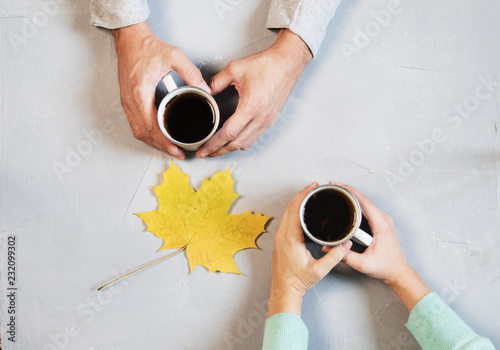 Couple in love holding hands with coffee on white marble table. Photograph taken from above, top view with copy space. maple leaf