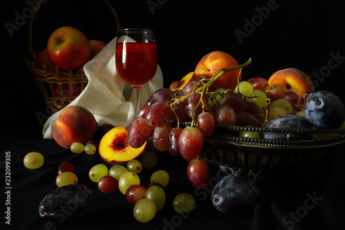 Fruit and a glass of red wine on a dark background