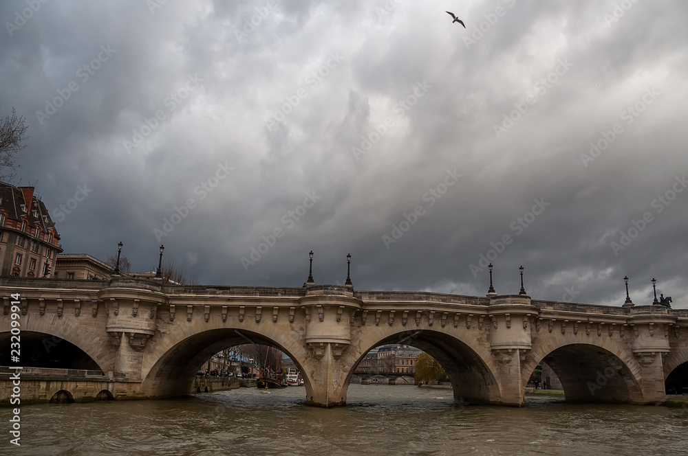 Bridge over the river in Paris and dramatic sky.
