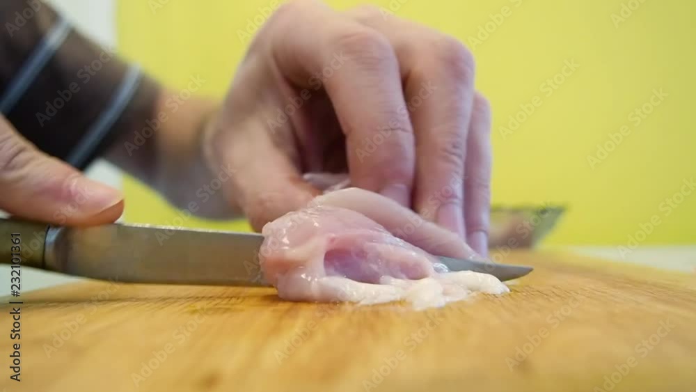Hands cutting chicken fillet on a kitchen board. Full HD. Hands cutting chicken fillet on a kitchen board. Full HD.
