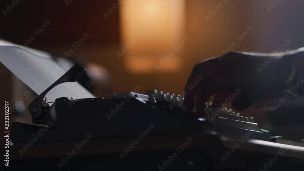 Low angle of a man typing at a vintage typewriter in slow motion