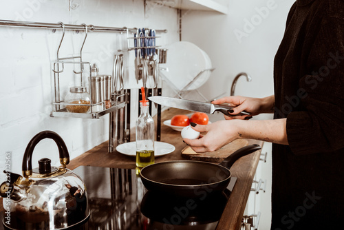 Fototapeta Naklejka Na Ścianę i Meble -  partial view of woman with tattooed hand making eggs on breakfast at home