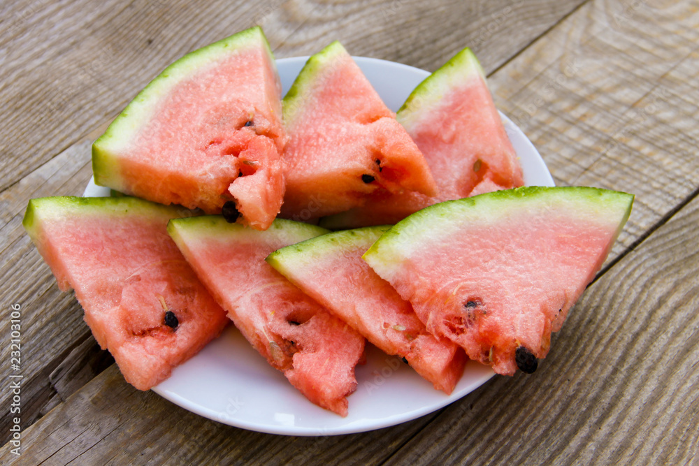 Sliced watermelon in a plate on wooden table Sliced watermelon in a plate on wooden table