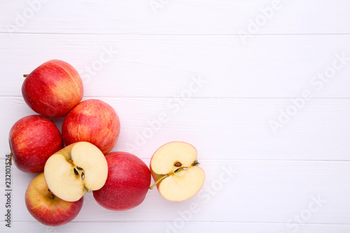 Fresh red apples on a white wooden background