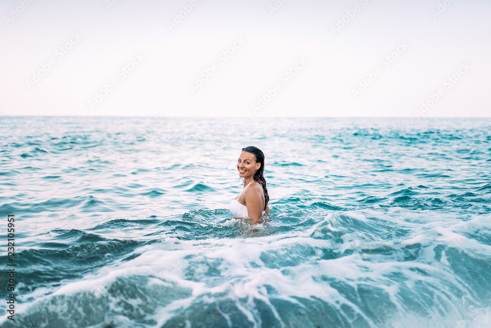 Portrait of a beautiful woman going for a swim in the sea.