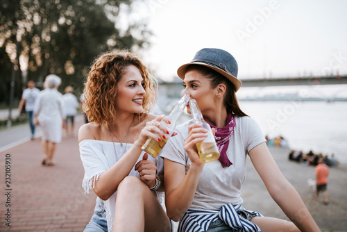 Girls enjoying drinks on the city quay in the summer. photo