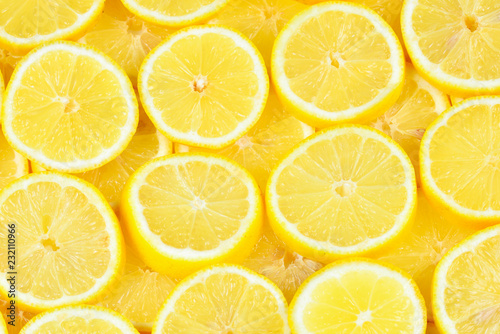 A slices of fresh juicy yellow lemons. Texture background, pattern.