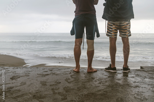 Bromance. Anonymous surfers watching waves on a stormy day. Surfing lifestyle. Bali waves.