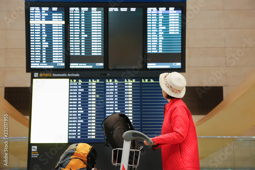 Photography Tourist woman in China international airport looking at the flight information b