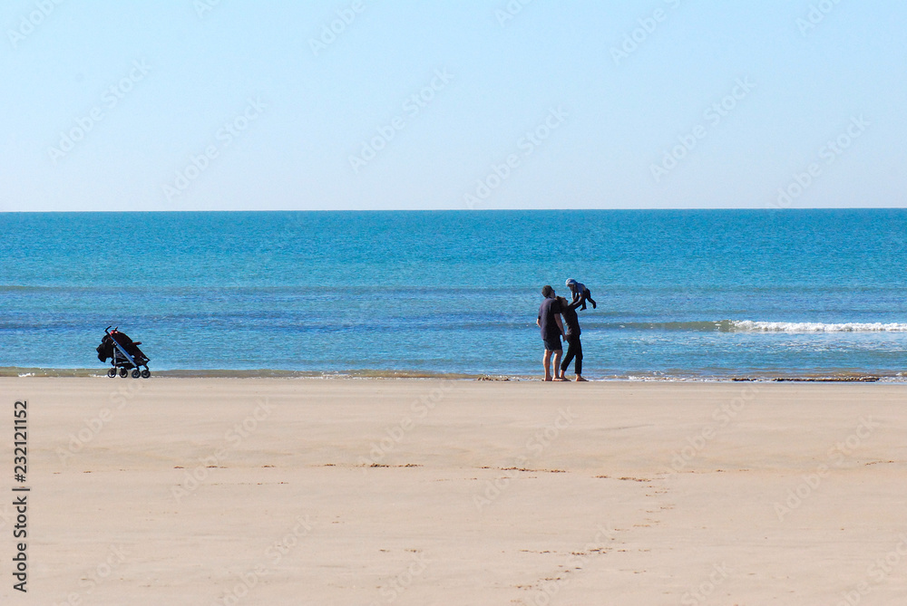 FAMILIA DISFRUTANDO DE UN PASEO AGRADABLE POR LA ORILLA DE LA PLAYA FAMILIA DISFRUTANDO DE UN PASEO AGRADABLE POR LA ORILLA DE LA PLAYA