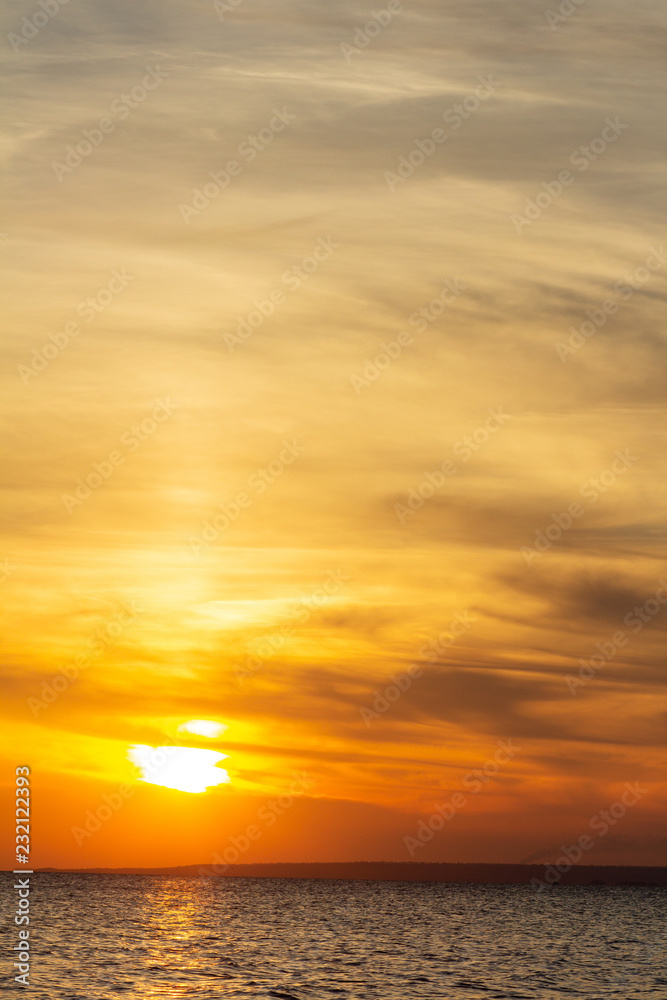 background of sunset on the sea, birds fly among the clouds lit by the rays of the sun