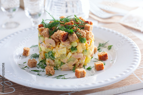 salad with smoked ham, corn, crackers on a white plate, horizontal