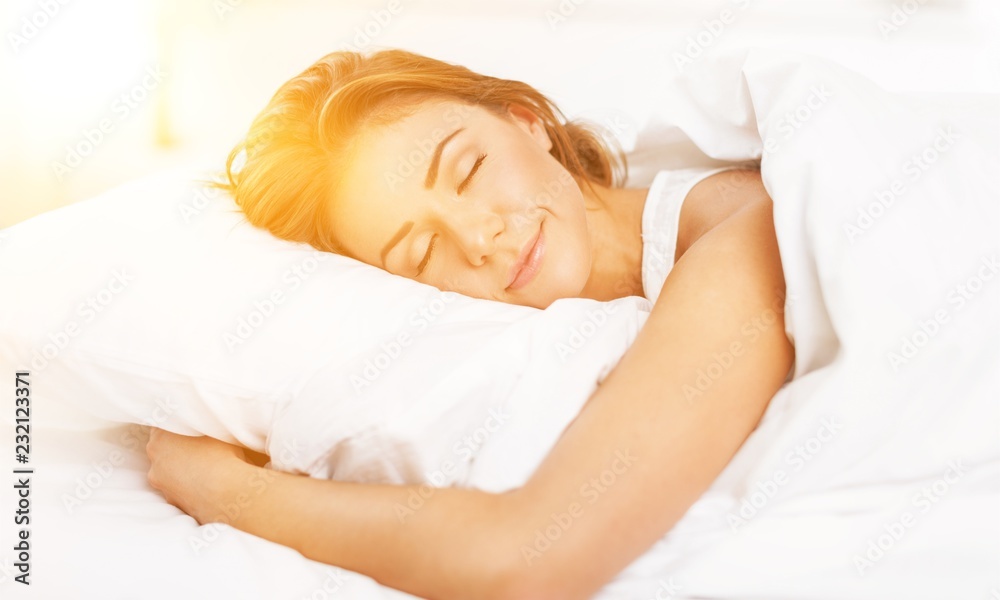 Young woman sleeping on the white linen in bed at home Young woman sleeping on the white linen in bed at home