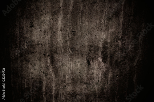 Dark grey concrete wall with imperfections and natural cement texture as background texture with dark vignetting