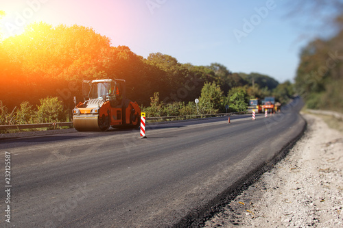 Carrying out repair works: asphalt roller stacking and pressing hot lay of asphalt. Machine repairing road