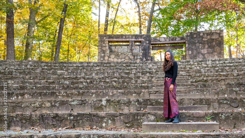 woman in sarong in amphitheater standing on steps looking towards stage woman in sarong in amphitheater standing on steps looking towards stage