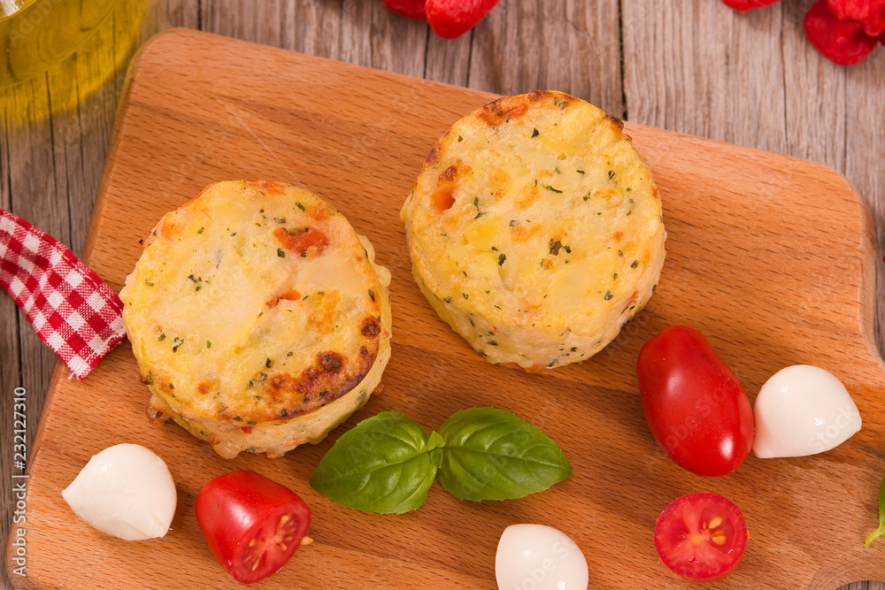 Potato gratins with mozzarella and tomatoes.
