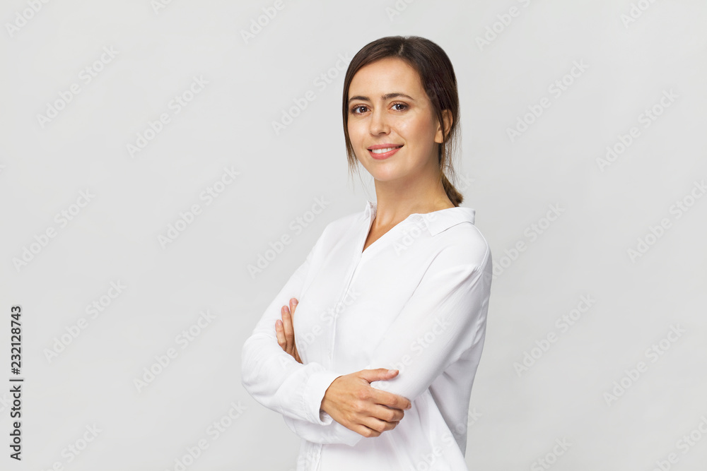 Amazing and cheerful smiling brunette with crossed arms in white shirt studio shot, isolated on white Amazing and cheerful smiling brunette with crossed arms in white shirt studio shot, isolated on white