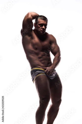 large powerful man showing his muscles in the Studio without a shirt on white background