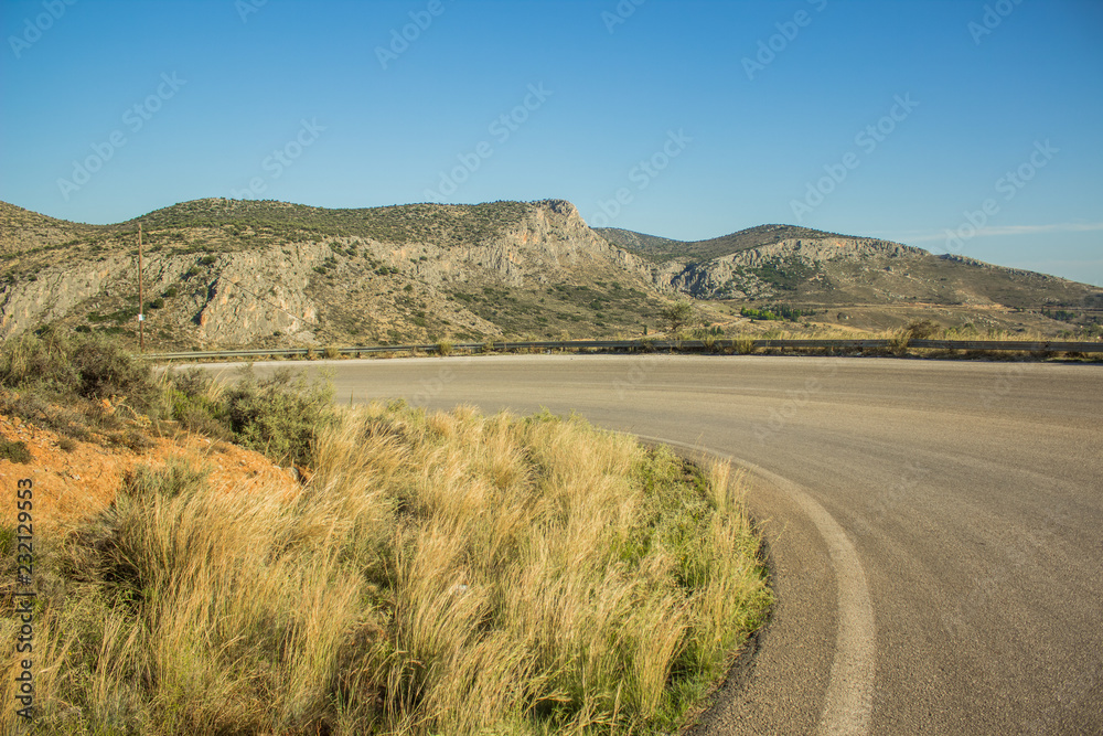 curved car road in rock mountain nature landscape in dry weather summer time Mediterranean sea district  