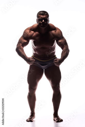 large powerful man showing his muscles in the Studio without a shirt on white background