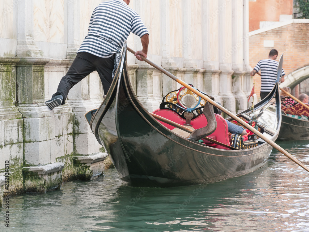 Venice channel and gondolier with passengers