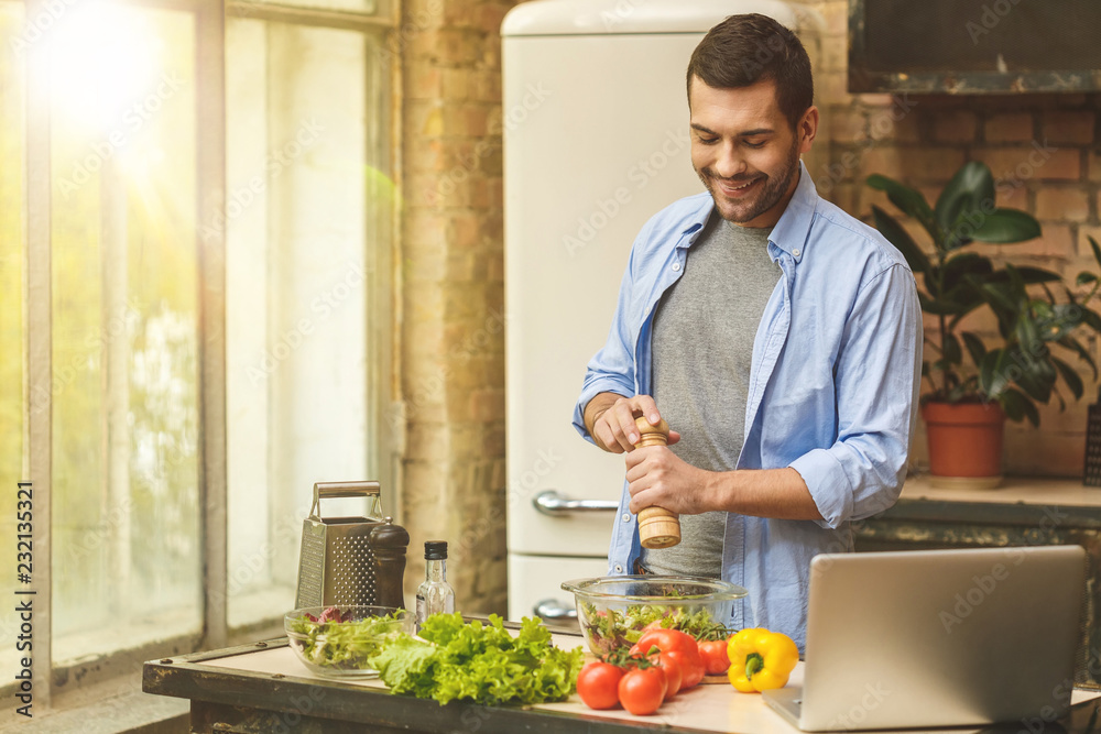 Man preparing delicious and healthy food in the home kitchen on a sunny day.