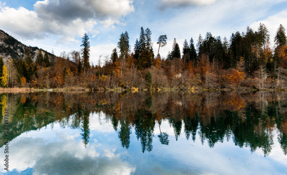 the picturesque Cresta Lake in the mountains of Switzerland near Flims in the Grisons on a beautiful fall day with colorful foliage and trees and reflections