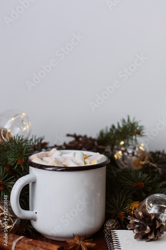 Chocolate or cocoa with marshmallow, notebook and garland on a wooden background.