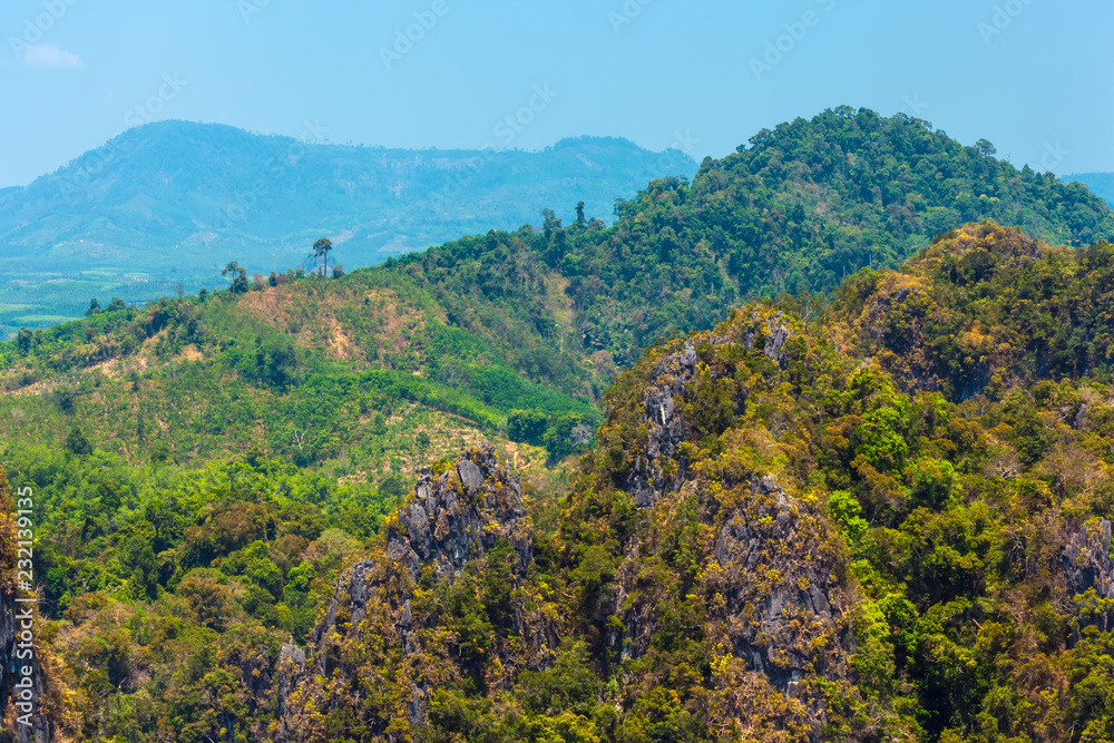 Jungle, dense tropical green forest on the tops of the rocky mountains, panoramic view of the valley. Tham Sua Thamsua Temple Enlightenment Center, Krabi, Thailand. Jungle, dense tropical green forest on the tops of the rocky mountains, panoramic view of the valley. Tham Sua Thamsua Temple Enlightenment Center, Krabi, Thailand.