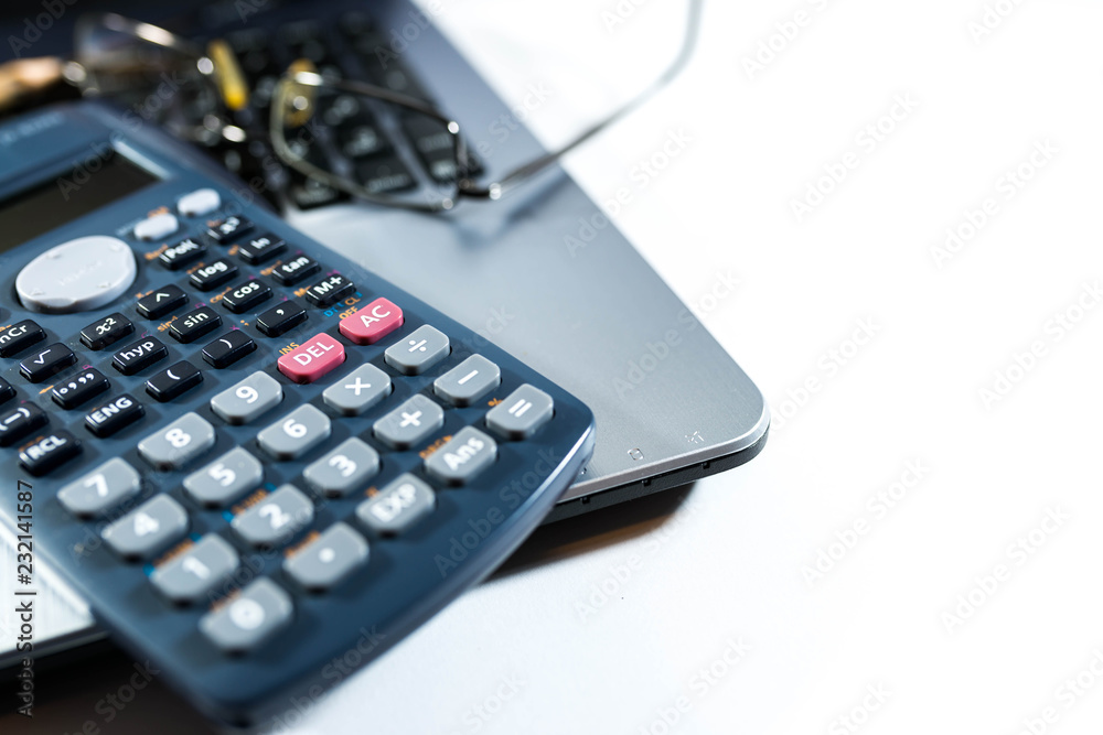 Obraz premium Eyeglass, pencil, calculator on laptop computer keyboard, business background image, space for text.