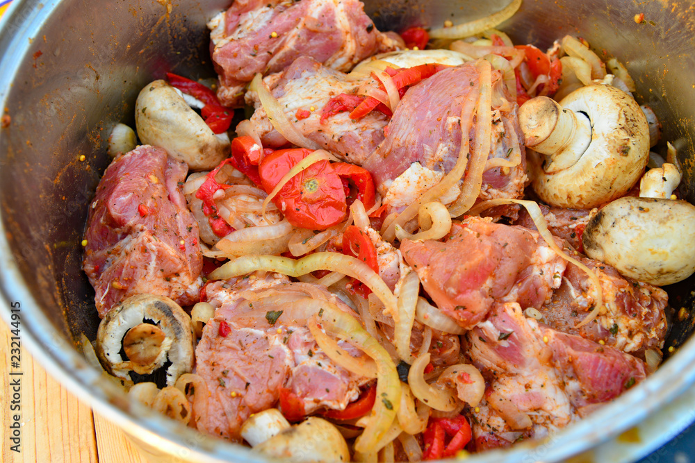 Raw meat in the marinade is in the pan, kebab with onions, mushrooms and meat. Raw meat in the marinade is in the pan, kebab with onions, mushrooms and meat.