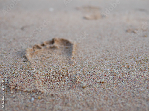 step of bare foot walk leave footprint on sand beach for holiday trip concept
