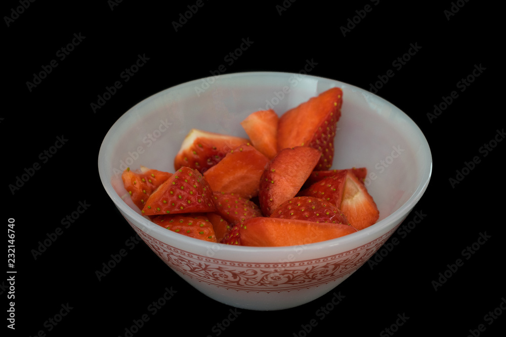 pieces of cut strawberries in a glass in black pieces of cut strawberries in a glass in black