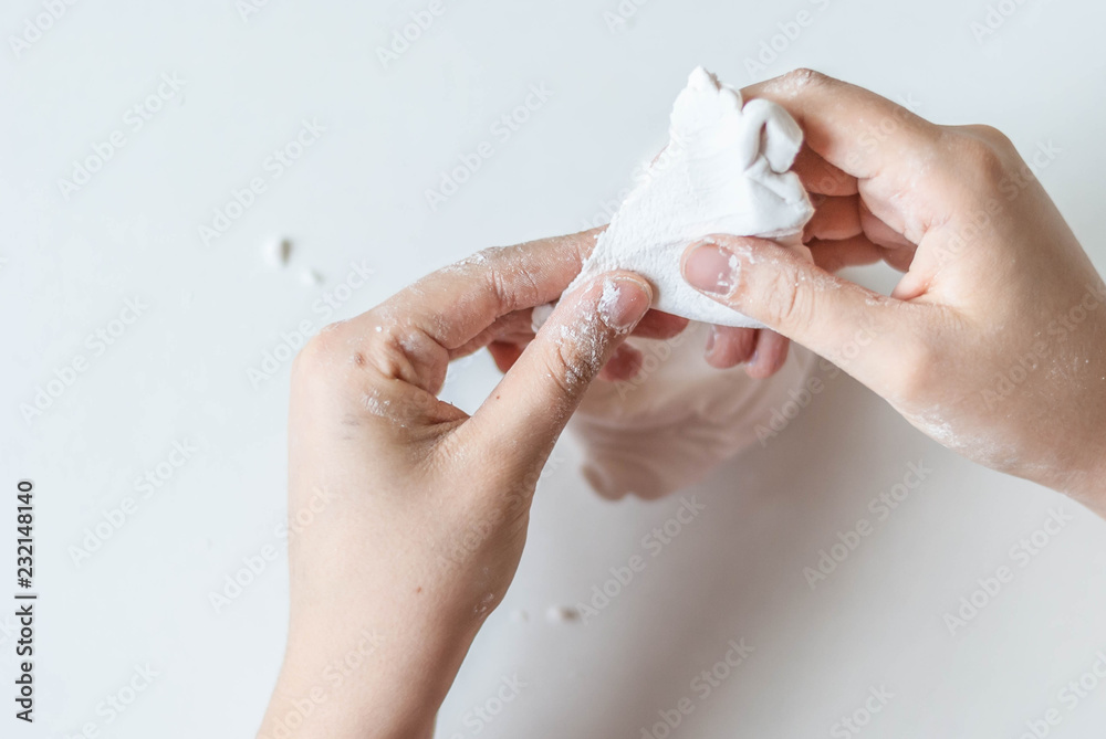 young artist hands in the process of creating a masterpiece of white  polymer clay on white, art concept Stock Photo